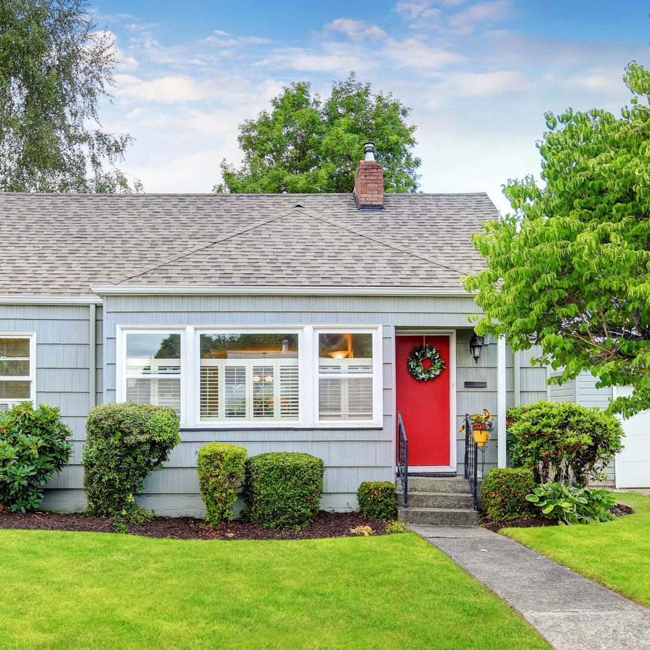 Exterior of small American house with blue paint Exterior of small American house with blue paint and red entrance door. Northwest, USA